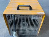 a small heater sitting on the ground in a warehouse