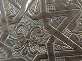 a silver plate with a star of david design on it