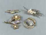 quatre types différents de broches et d'épingles sur un fond gris
