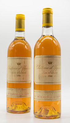 two bottles of wine sitting next to each other on a white surface