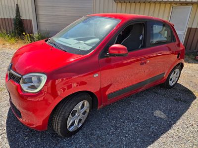 une photo d'une petite voiture rouge garée devant un immeuble