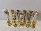 six verres à vin en argent et en or alignés sur une surface blanche