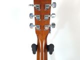 the headstock of an acoustic guitar on a stand against a white background