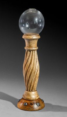 une image représentant une boule de verre posée sur un socle en bois