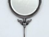 un miroir sur lequel est représenté un oiseau et dans lequel se trouve une clé