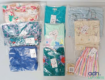 de nombreux types de vêtements différents, rangés dans des sacs posés sur la table