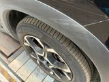 a close up of a car ' s tire on the side of the road