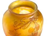 a yellow vase with a design on it on a white background