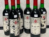 quatre bouteilles de vin sont alignées sur un comptoir