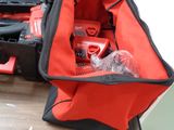 a red tool bag with tools in it on a table