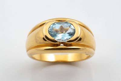 une image d'une bague en or avec une pierre en topaze bleue