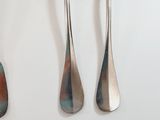 three spoons and a fork on a white table