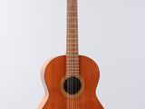 a small wooden guitar hanging from a white wall