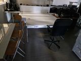 une pièce équipée d'un bureau, de chaises et d'un réfrigérateur