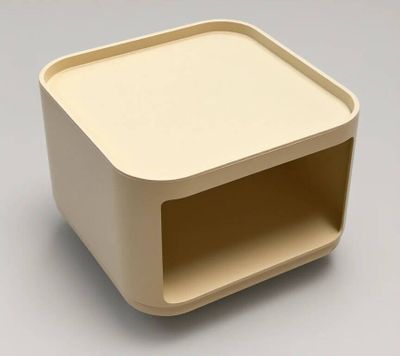 une boîte blanche avec un couvercle beige posée sur une surface grise