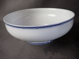 a white bowl with blue trim on it on a table