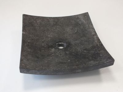 un objet noir de forme carrée, percé d'un trou