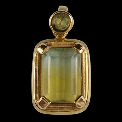 un gros plan d'un pendentif orné d'une pierre verte