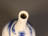 a white and blue vase with a blue design on it