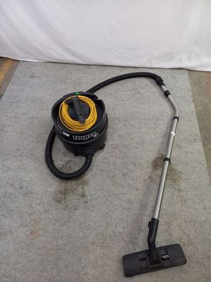 un aspirateur posé sur le sol à côté d'un tuyau