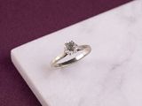 an image of a diamond ring on a marble surface