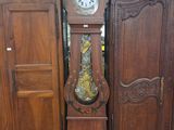 une horloge de parquet posée devant une armoire
