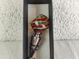 bottle stopper in a black box with a red and green swirl design