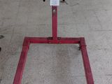 un support rouge sur lequel repose un objet noir, dans un garage