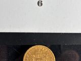 a close up of a gold coin in a box on a table