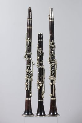 two clarinets sitting side by side on a white surface