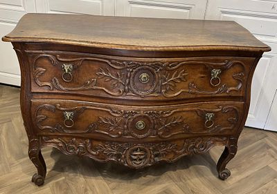 une commode ancienne posée sur un parquet dans une pièce