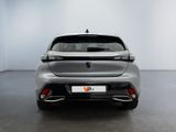 the rear end of a silver car in a white room