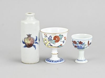trois vases et une tasse posés les uns à côté des autres sur une table