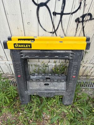 a yellow and black tool stand in front of a wall with graffiti