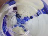 a person holding a blue and white object in a glass