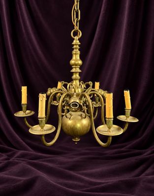 un lustre en laiton à cinq bougies sur fond violet
