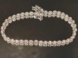 gros plan d'un bracelet en argent sur une surface noire
