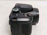 a black camera sitting on a table with a white background