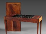 un piano ancien en bois, doté d'un plateau en marbre et posé sur un meuble