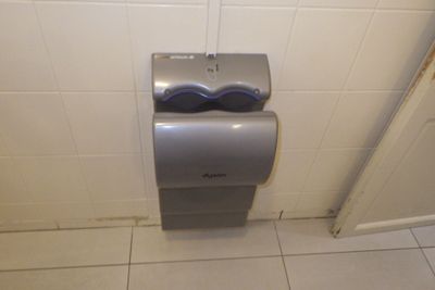 un distributeur de papier toilette dans un coin des toilettes