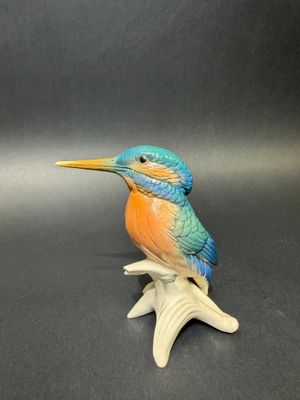 a figurine of a bird sitting on a branch
