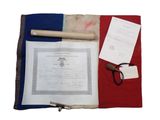 un drapeau rouge, blanc et bleu sur lequel figurent un document et une paire de ciseaux