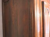 a wooden armoire in the corner of a room