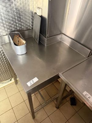 a metal table with a basket on it in a kitchen