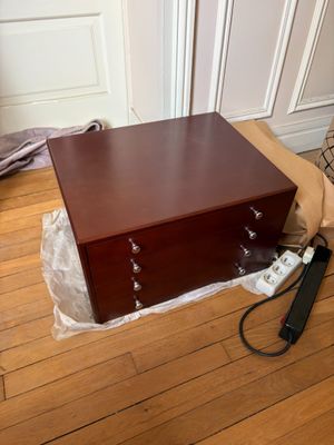 une commode en bois posée sur un parquet en bois massif