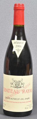 bottle of red wine sitting on a gray surface with a red cap