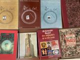 several books are sitting on a table with a clock in the middle