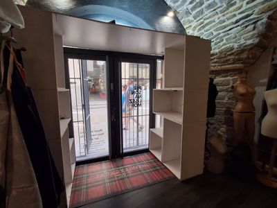 une grande porte ouverte donnant sur une pièce où se trouve un tapis à carreaux