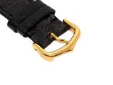 black leather watch strap with gold buckle on a white background