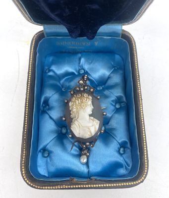 une boîte en velours bleu contenant une broche en argent